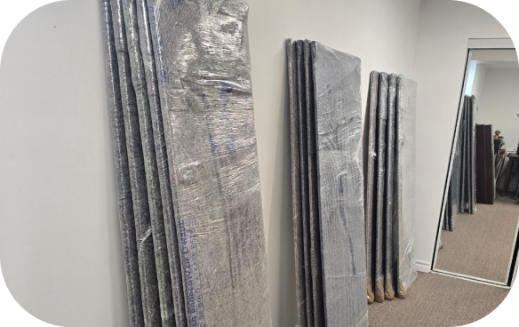 Office panels and equipment wrapped in moving blankets and stretch film, ready for a commercial relocation